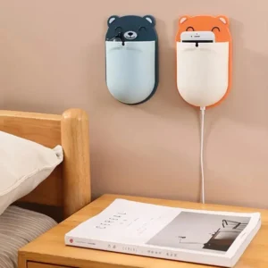 Close-up of a hand placing toothpaste into a grey bear toothbrush holder next to a sink.